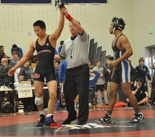 Yo Akiyama, left, has his hand raised after winning by pin in the first round of the state tournament against an opponent from Episcopal High School. Akiyama won the tournament and was named most outstanding wrestler.