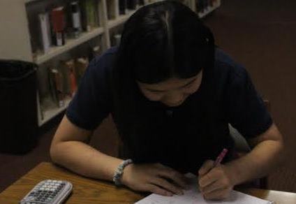 A student studies for the math competition in the library.