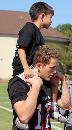 Senior Stephen Spears holds up a kindergartner during the traditional "Cookie Monster" cheer.