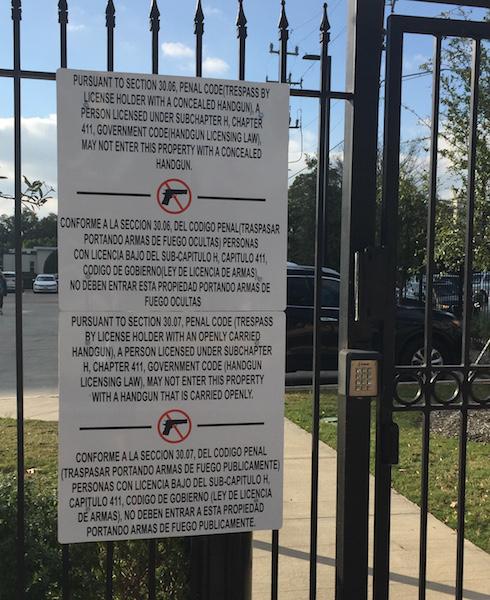 Another sign with St. John's weapons policy is posted to the gate leading to St. Luke's parking lot.