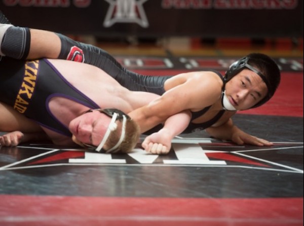 Senior Yo Akiyama pins down a Kinkaid opponent at the 8th annual War on the Floor wrestling tournament, which started off the wrestling season last November.