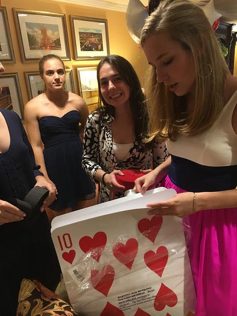 Senior Lucy Elkins opens up a giant deck of cards while decorating Belmont Village.