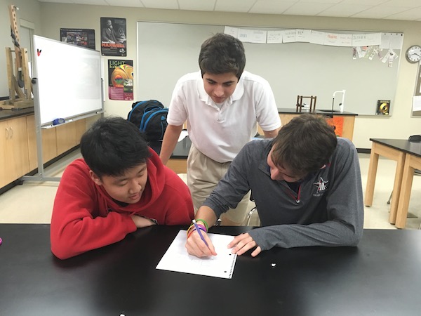 Science Olympiad club founders Zachary Boroughs and Kevin Jung work with club member junior Johnny Coudsi.