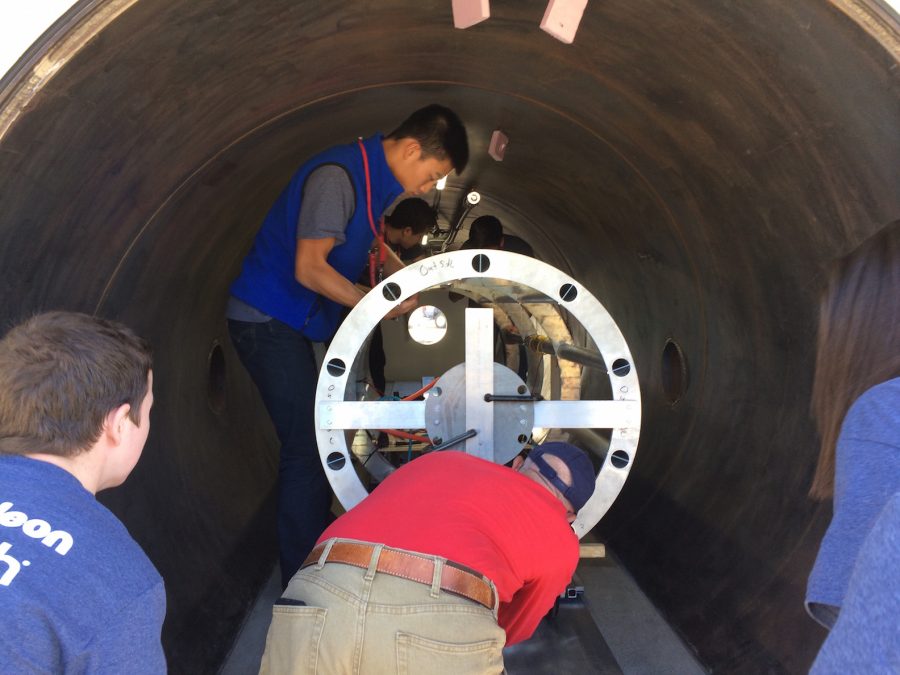 From left: senior Robert Gottschalk, junior Michael He (far back), adviser Franco Posa and junior Elizabeth Award test the pod in a vacuum chamber to ensure that its electronics would not overheat. 