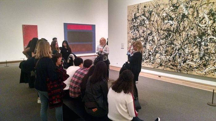 The class observes work by Jackson Pollock, an American artist known for his unique style of drip-painting.