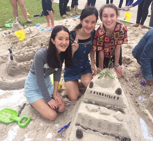 Sophomores Margaret Gorman, Catherine Gorman and Shelby Jordan present their first-place sandcastle, fondly known as the chateau-bateau (boat castle). 