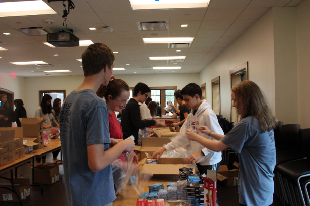 Over 100 sophomores separated into three service shifts to sort books and care packages.