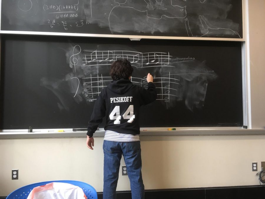 Junior Ethan Pesikoff works on a musical problem on the chalkboard. 