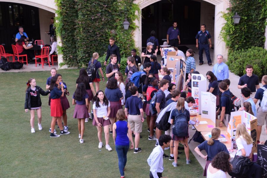 Students and faculty mill about in the middle of Club Fair. 