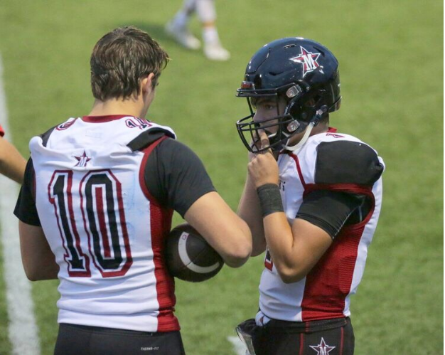 Gow (left) gives Caldwell, the new starting quarterback, advice before the game.