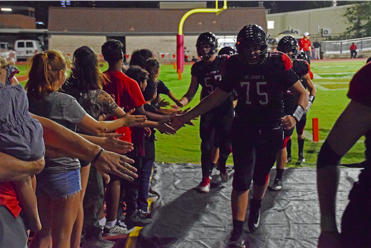 Football players high-fived the children at halftime.