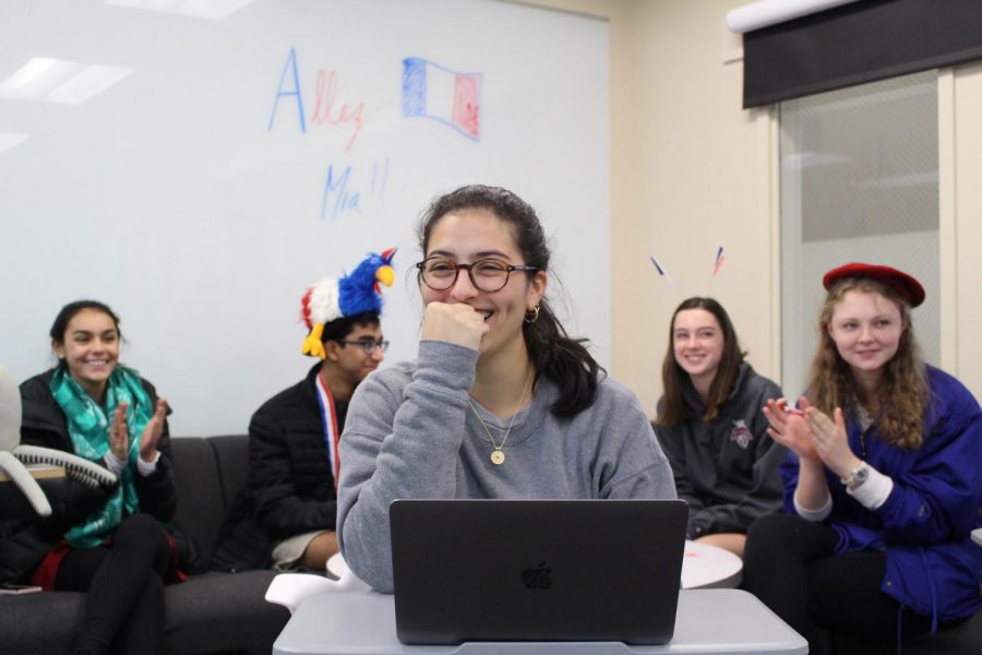 Junior Mia Fares competes in a nationwide French Kahoot! game while fellow peers encourage her.