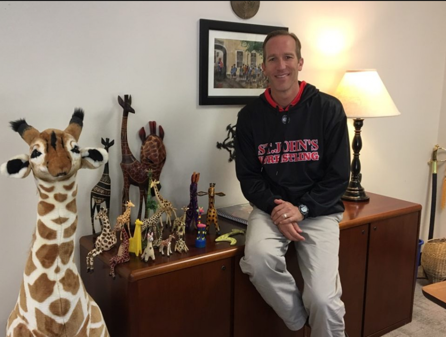 Tom+McLaughlin+poses+next+to+the+giraffes+in+his+office.+McLaughlin+was+recently+promoted+to+permanent+Head+of+Lower+School.