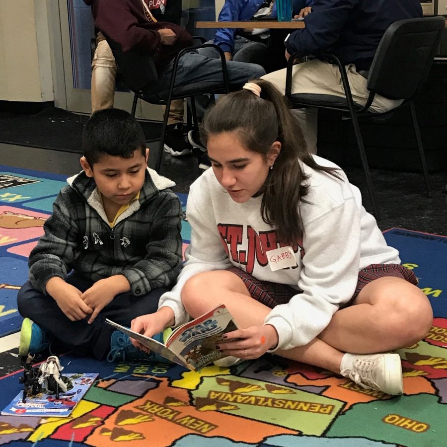 Freshman Gaby Jammar reads books to children at the Nehemiah Center.