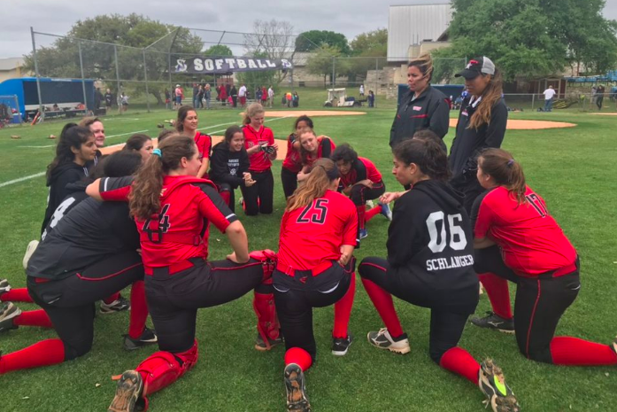 The softball team huddles up after their undefeated weekend.