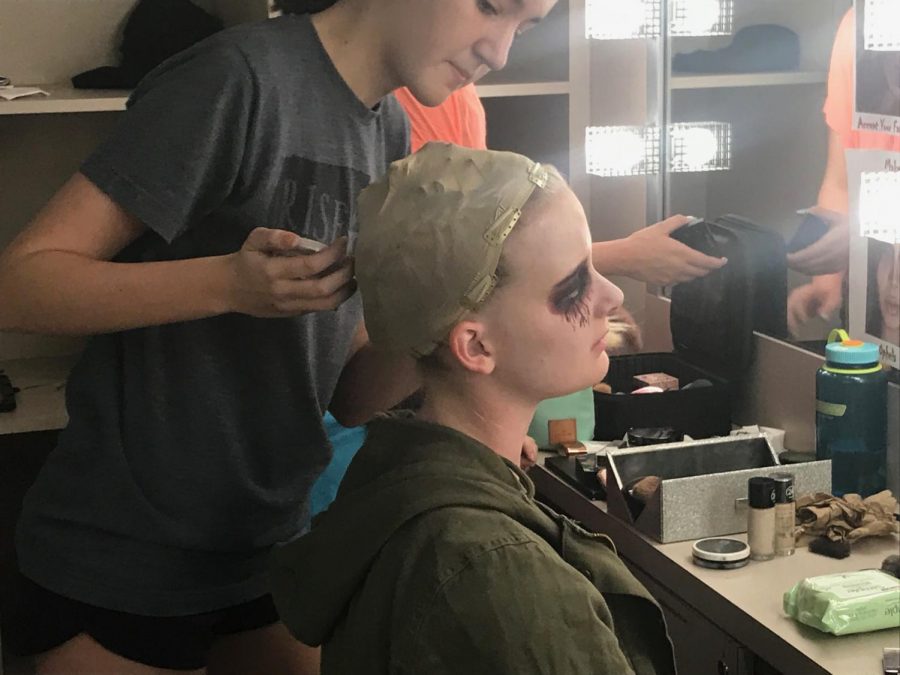 Freshman Noelle Alexander finishes sophomore Eve Kroenckes zombie makeup.