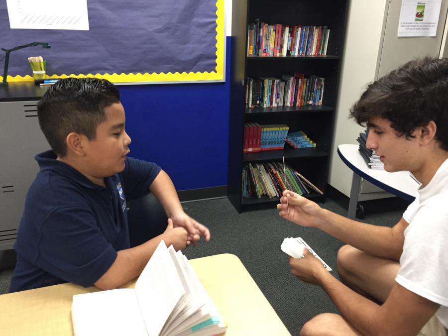 Freshman Chethan Shultz practices flashcards with a student at Etoile Academy.