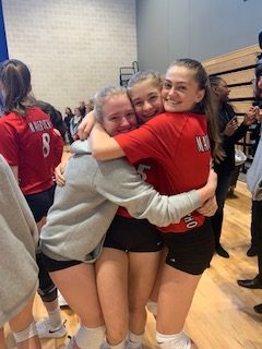 The girls volleyball team embraces after clinching an SPC victory.