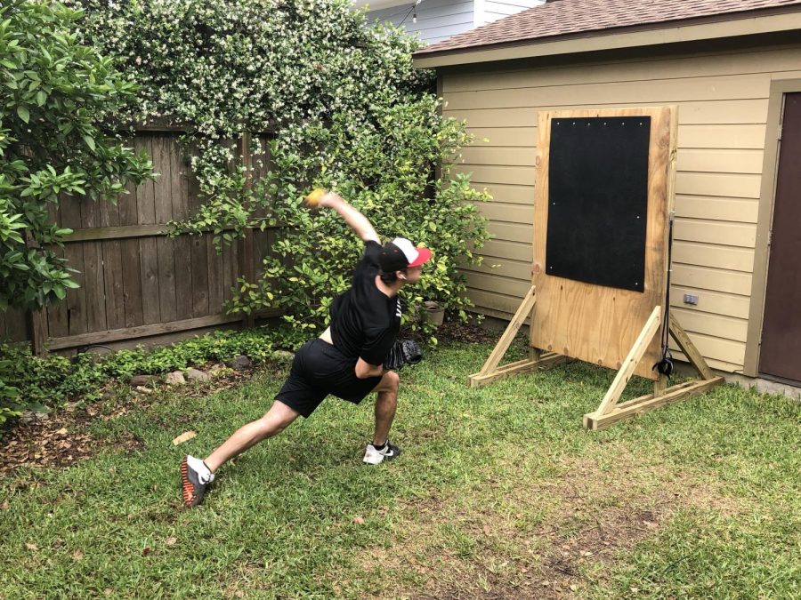 Hay throws a pitch in his backyard while in quarantine.