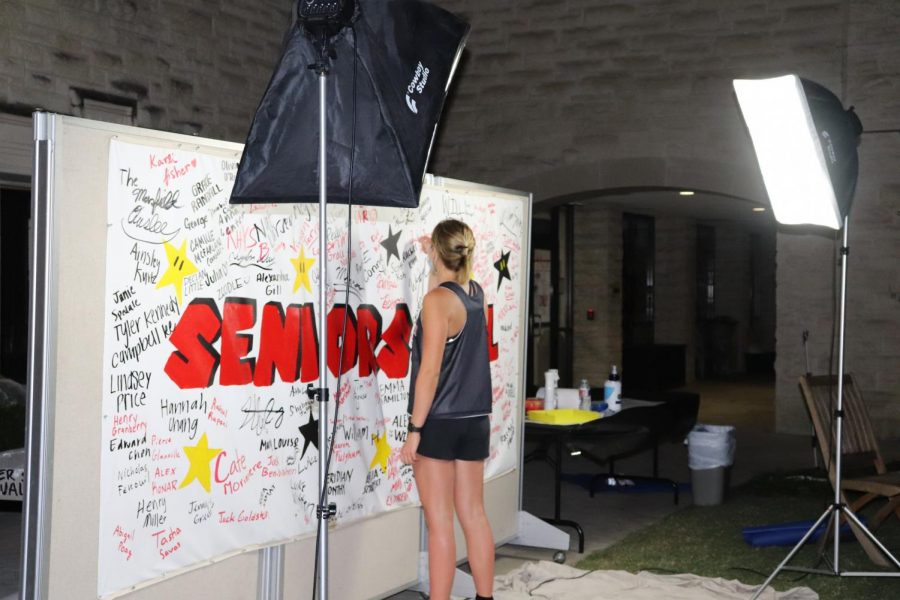 Caroline Pressler signs her name on the Senior Mural.