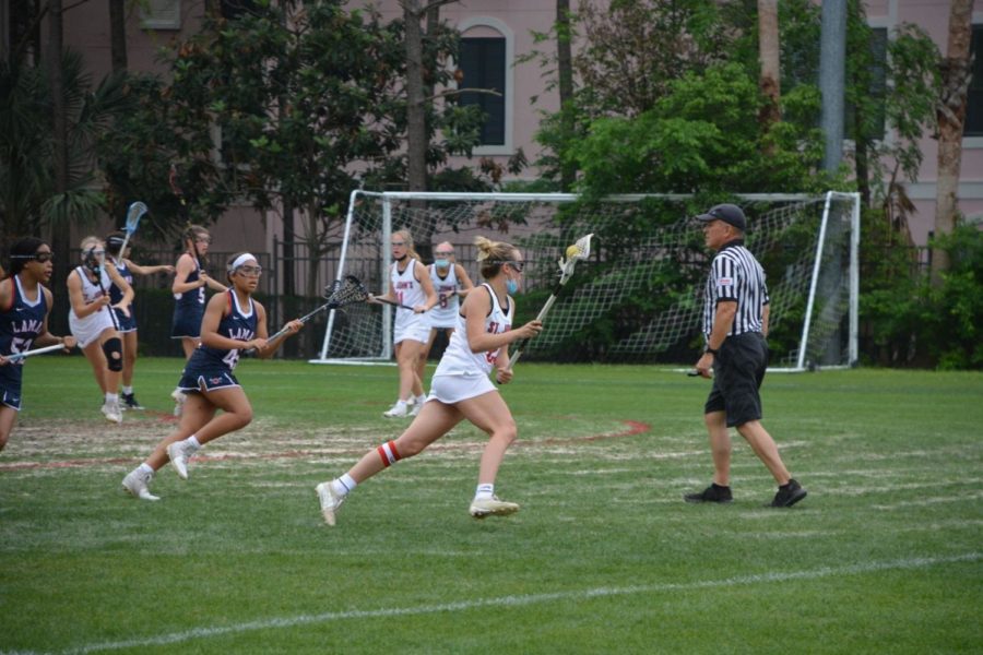 Senior captain Caroline Pressler cradles the ball away from Lamar defenders. On May 2, the girls’ lacrosse team defeated Lamar to win the city championship.