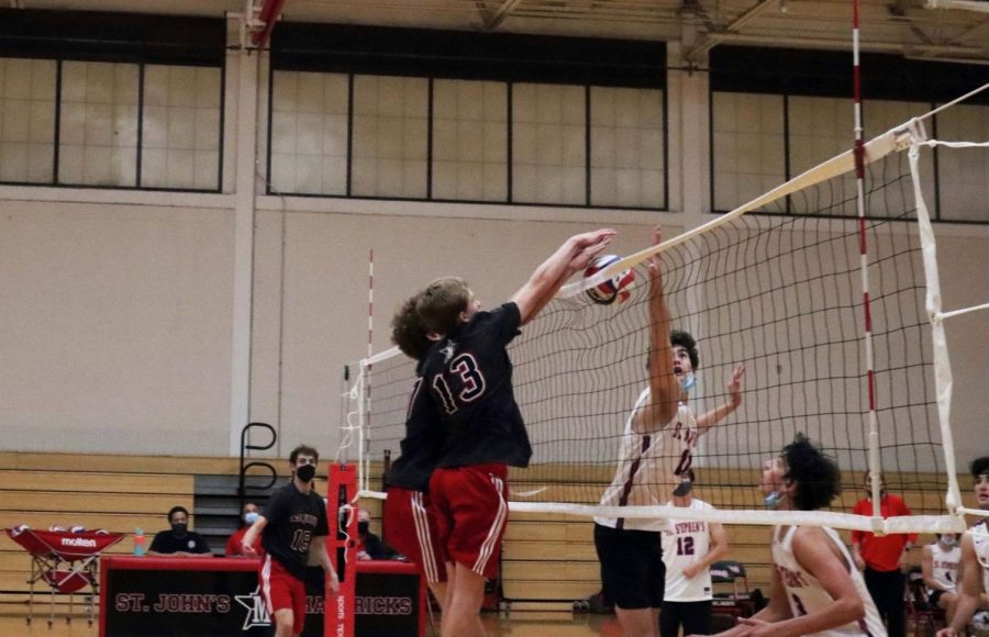 Sophomore Jackson Byers spikes the ball over the net.