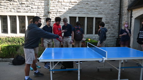 Students play ping pong with each other in the Plaza.
