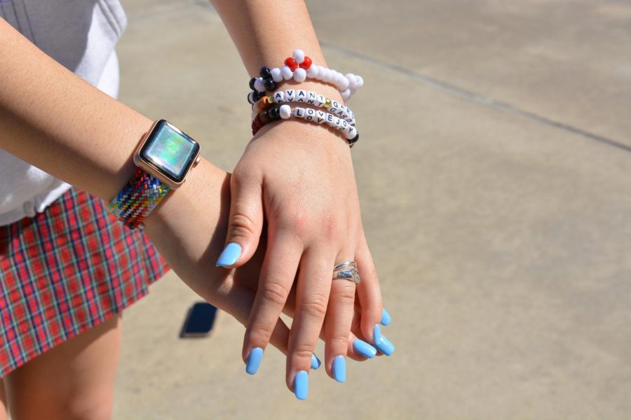 Collins uses beaded bracelets, silver rings and blue nail polish to accessorize her uniform. 