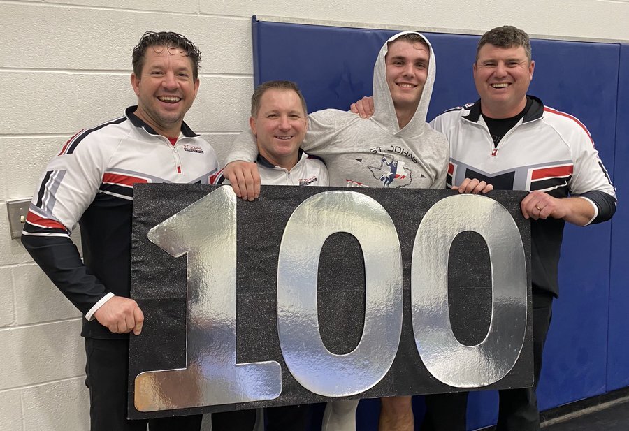 Senior+John+Perdue+celebrates+his+100th+wrestling+win+with+coaches.