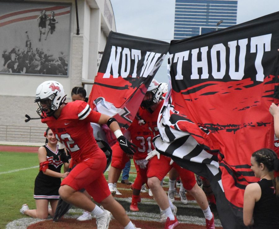 Senior Blake Masterson runs through the Not Without Honor banner.