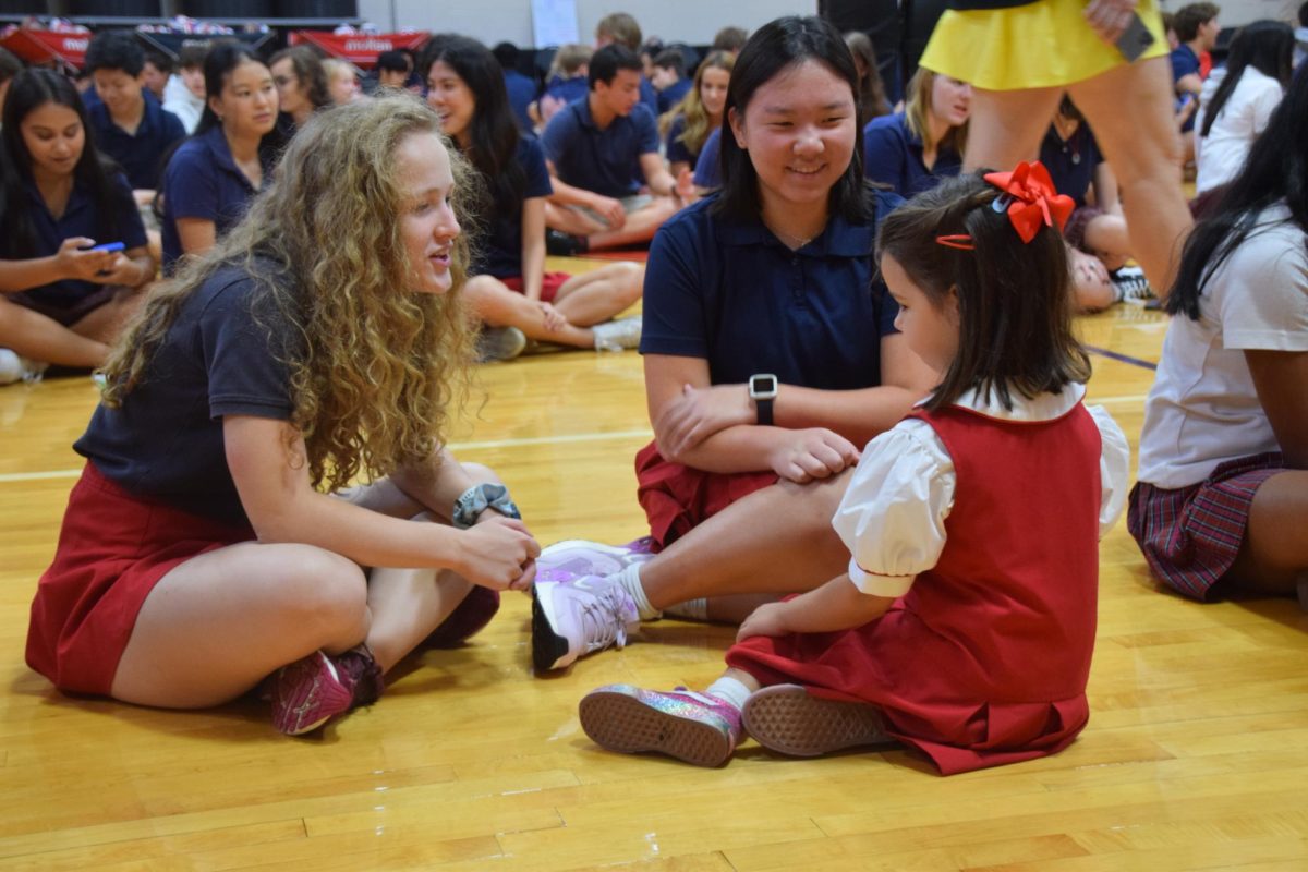 Seniors Janie Boom and Kenna Lee celebrate their last first day of school by chatting with kindergarten student Osa Chapman, who is celebrating her first first day of school.