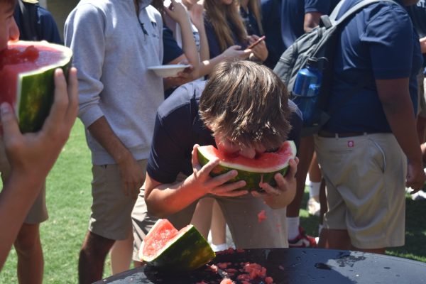 Freshman Luke Brasher devours a slice of watermelon during the watermelon-eating contest.
