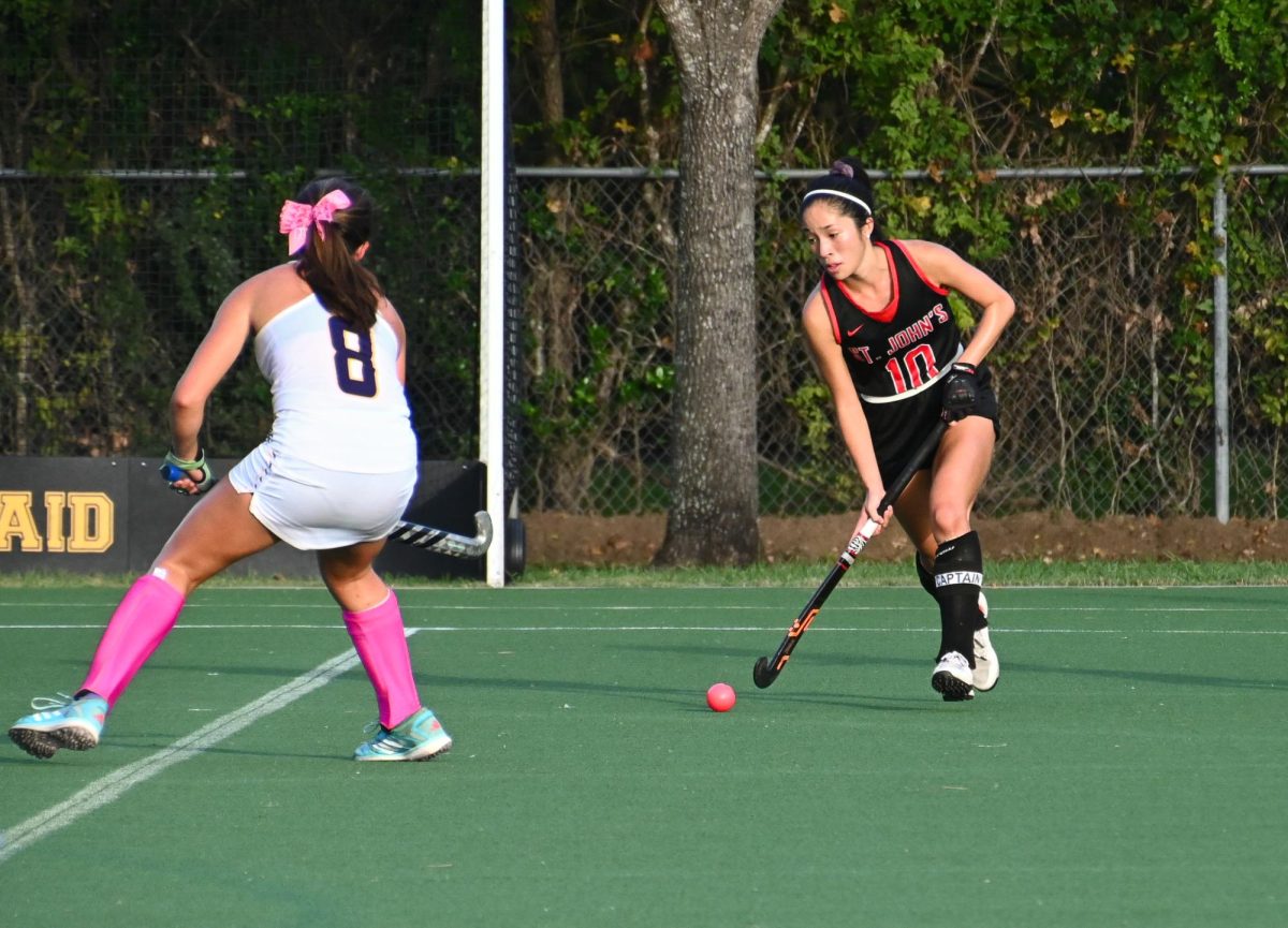 Kaitlyn Chang dribbles around her opponents as she makes a push up the field towards the goal. 