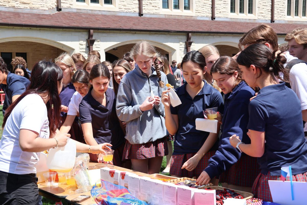 Students learn about and taste Filipino drinks and snacks from junior Alexys Tantucos booth. 