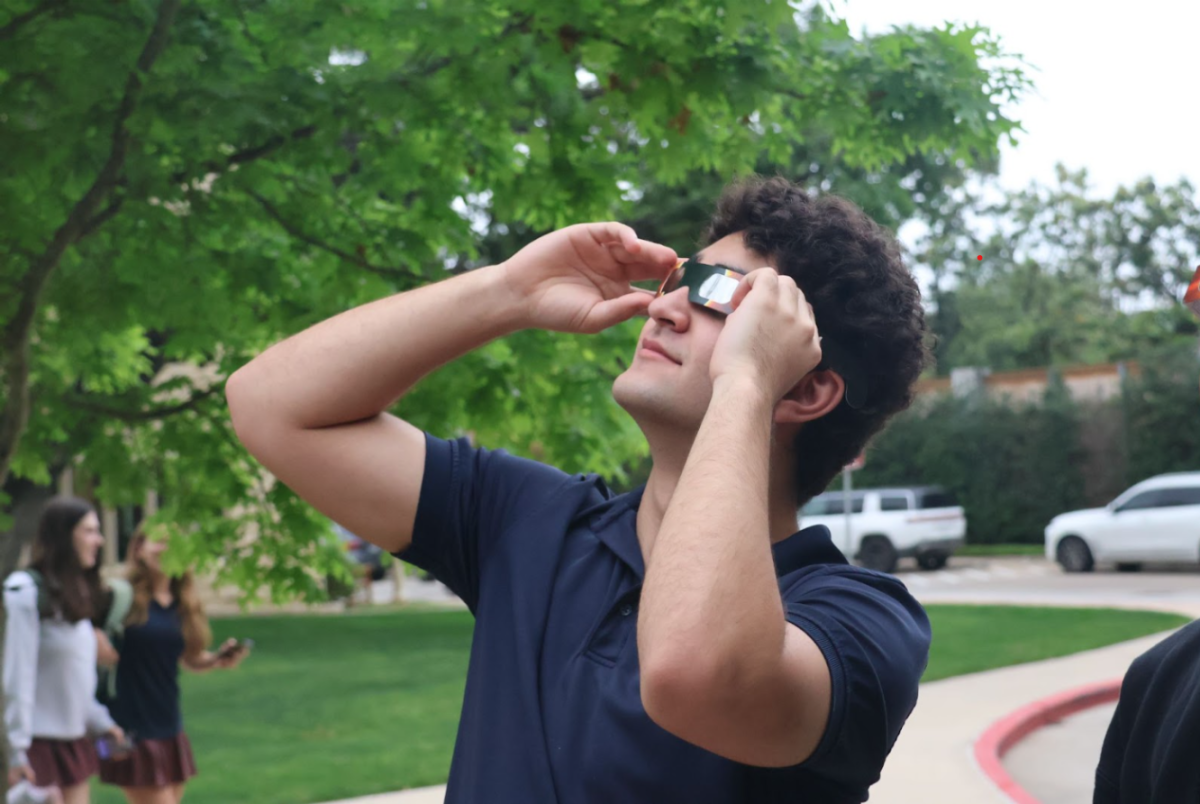 Junior Caiman Moreno-Earle dons his eclipse glasses in order to view the spectacle safely. 