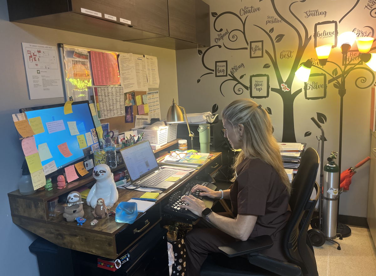 Director of Clinical Services Colleen Kimball finishes up notes in between seeing 40-75 patients in a day last Friday.  